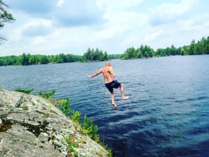 mies hyppää järveen